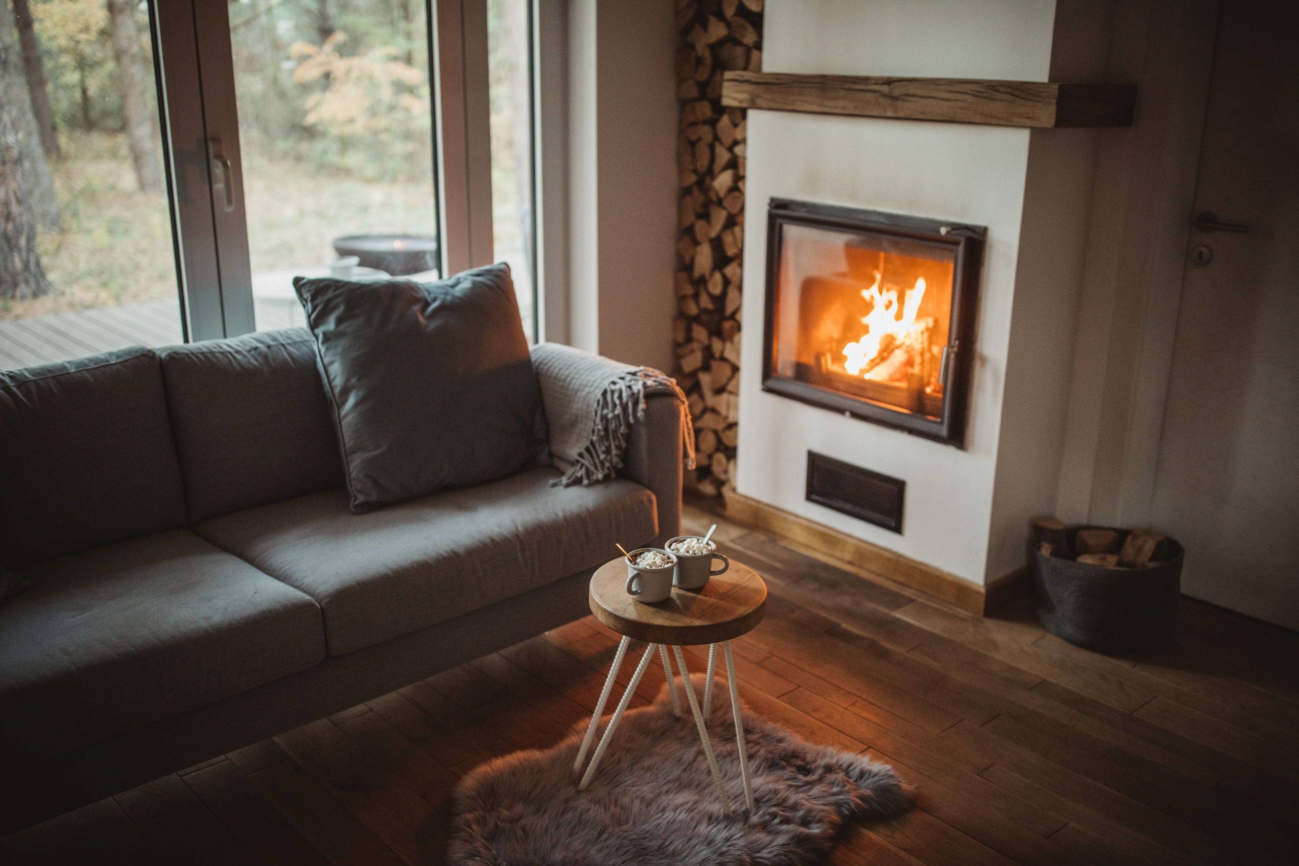 Herfstachtig interieur met open haard en grijze bank