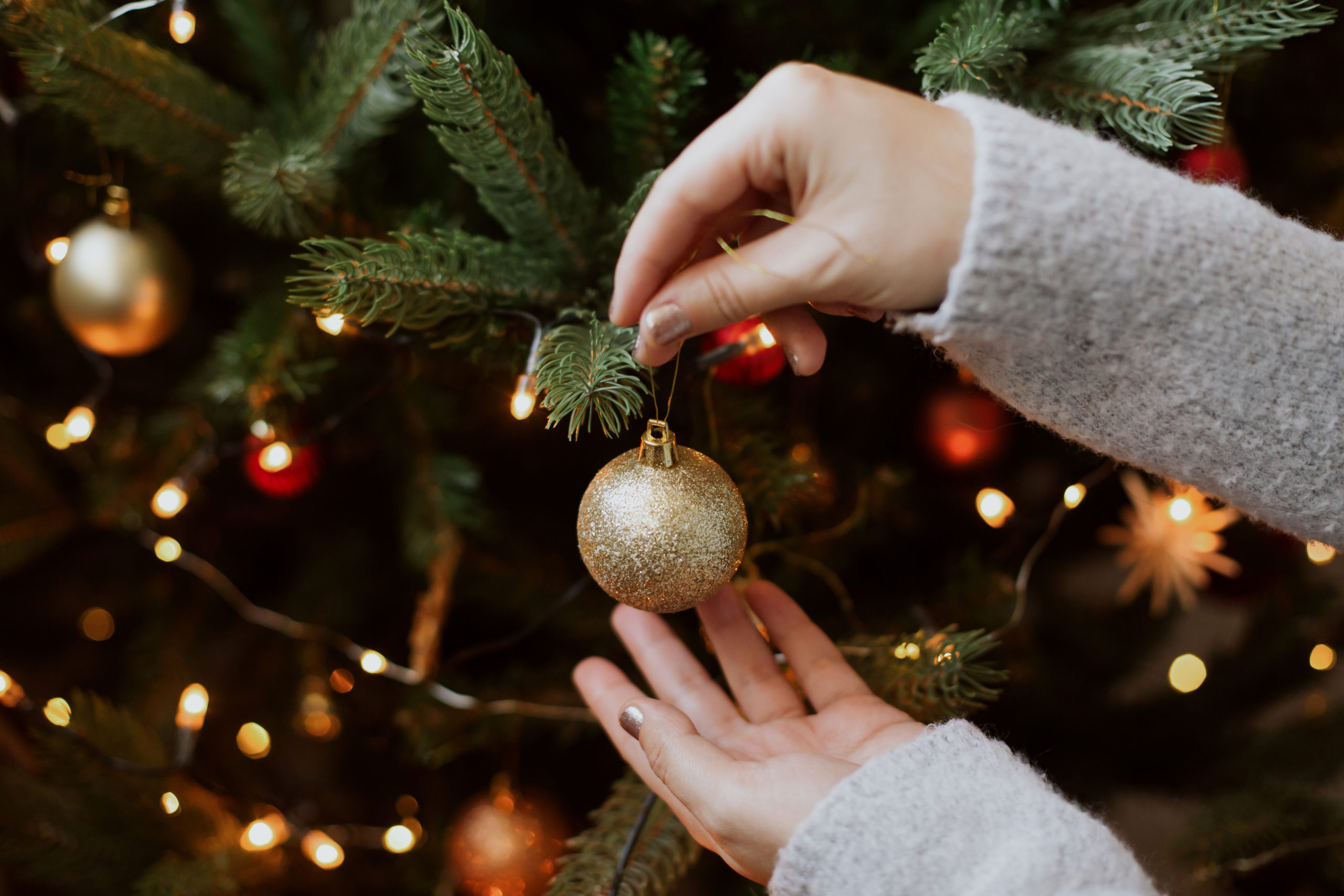 Kerstboom versieren met gouden glitterbal